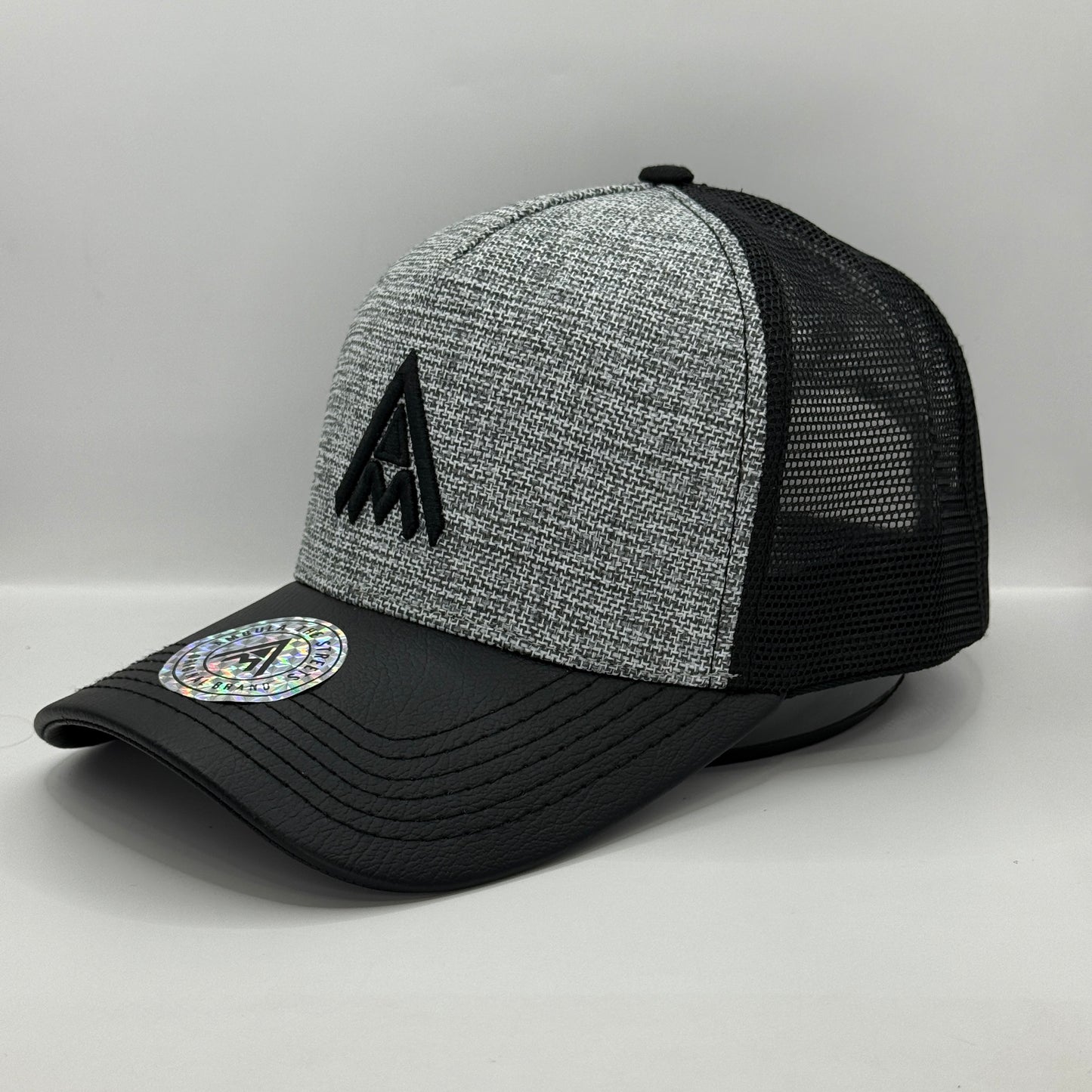 Gorra Trucker AMBULA - Edición "Textura Contraste" (Gris Jaspeado & Visera Símil Cuero Negra)