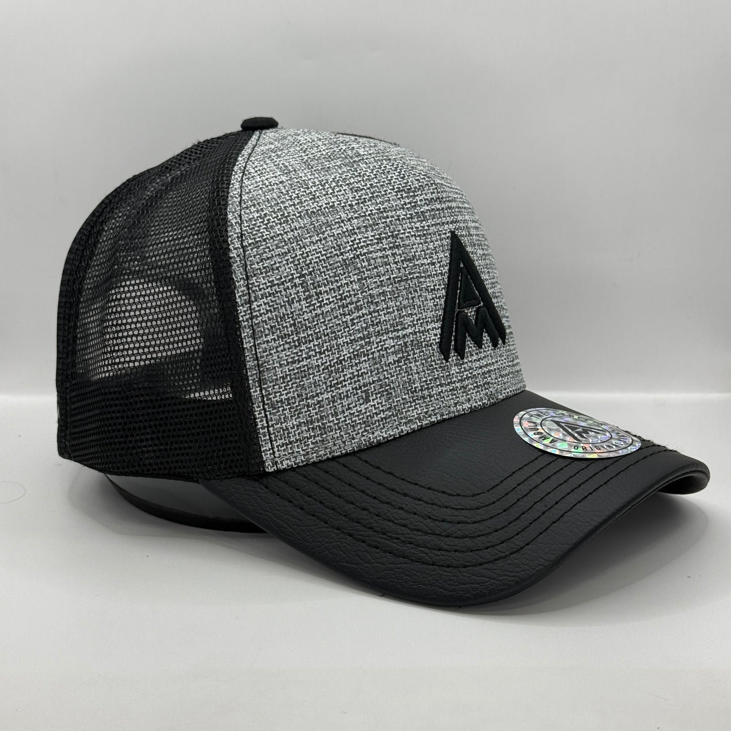 Gorra Trucker AMBULA - Edición "Textura Contraste" (Gris Jaspeado & Visera Símil Cuero Negra)
